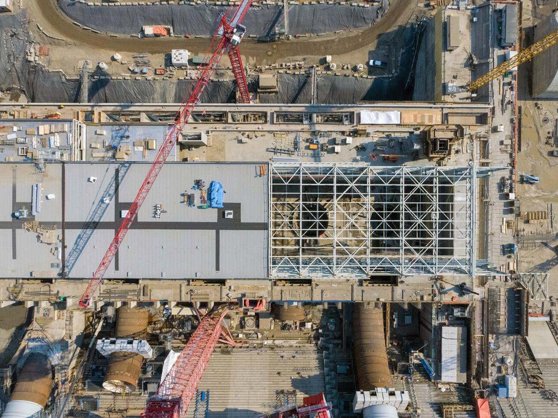 The structural steel placement on the main service bay roof at the powerhouse nears completion. | June 2021