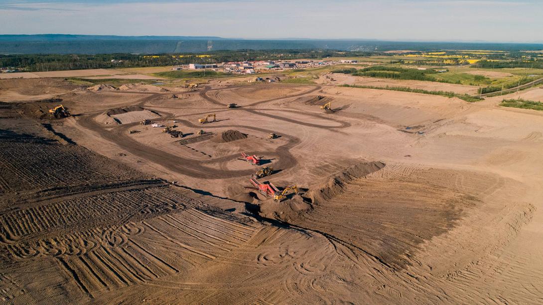 An aerial view across the 85th Ave industrial lands where glacial till is sourced and used to build the dam. | July 2022