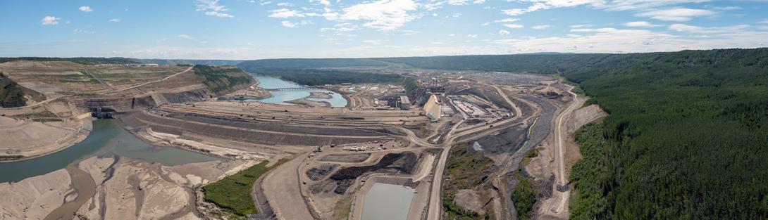Panorama view, looking downstream over the diversion tunnel inlet portals at left, the dam in the centre, and the approach channel on the right. | July 2022