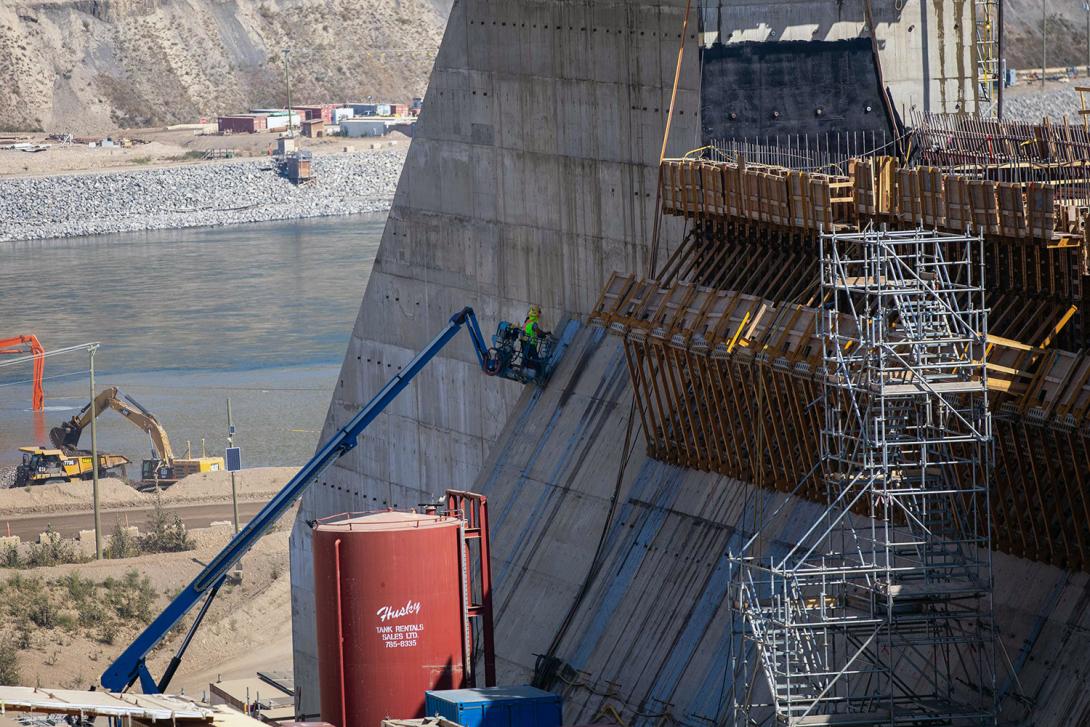 Finishing concrete and plugging formwork holes on the right spillway training wall. | August 2022