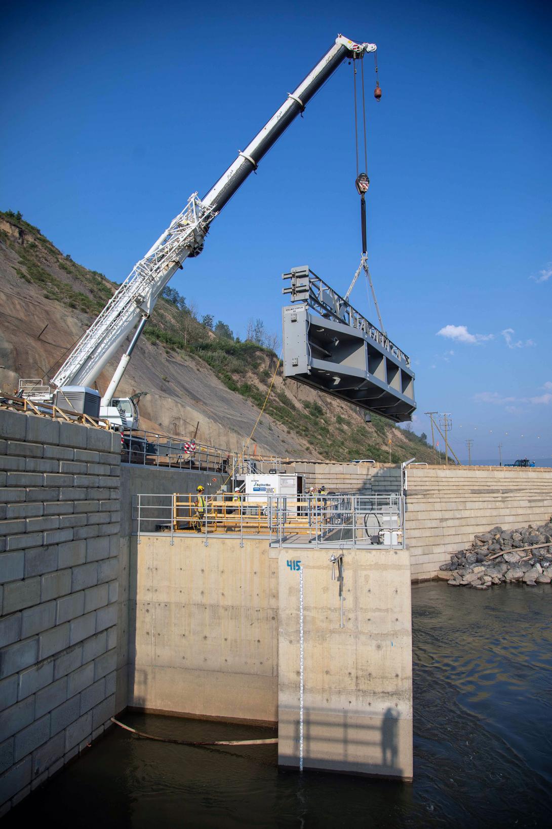 The last of eight stoplogs is lowered over the outlet of Diversion Tunnel 2 to seal the tunnel. | June 2023