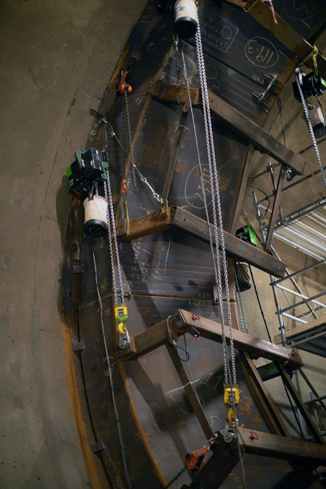 Segments of the ring are hoisted into position and welded.  Crews will complete the welds to the embedded steel in the tunnel walls. 