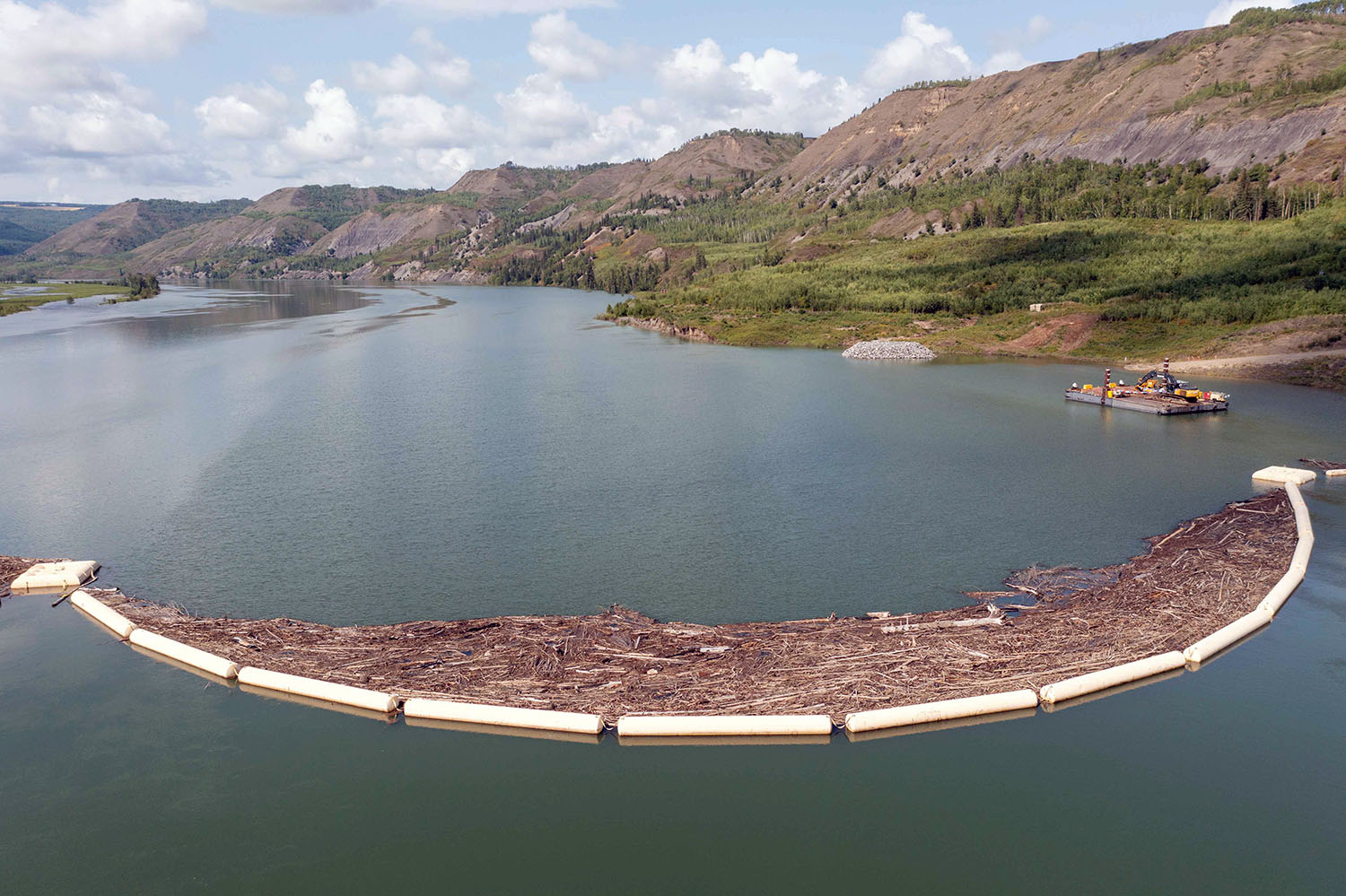 The temporary debris boom catches debris that floats down the river towards the diversion inlet portals. Permanent debris management booms will be installed on the reservoir to stop material flowing into the approach channel. | August 2023