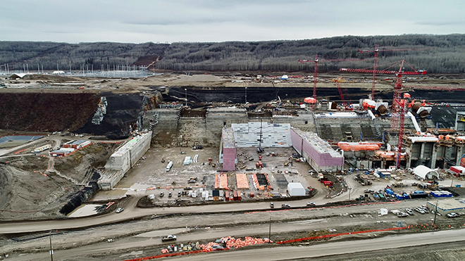 Looking south at the spillways buttress (left) and the Site C powerhouse, under construction (right).