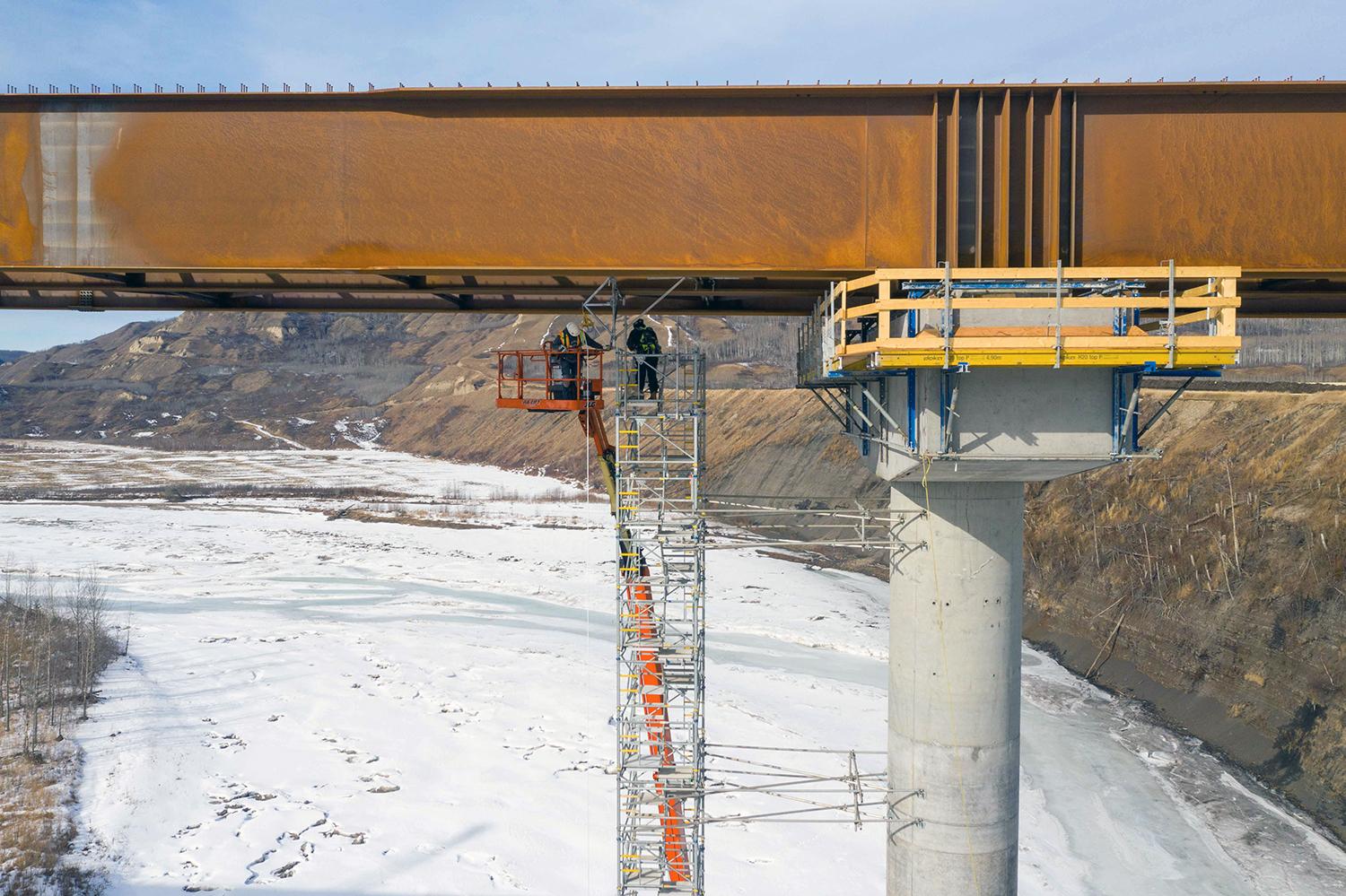 Girder installation is complete, and workers remove scaffolding from the Halfway River bridge. | March 2021