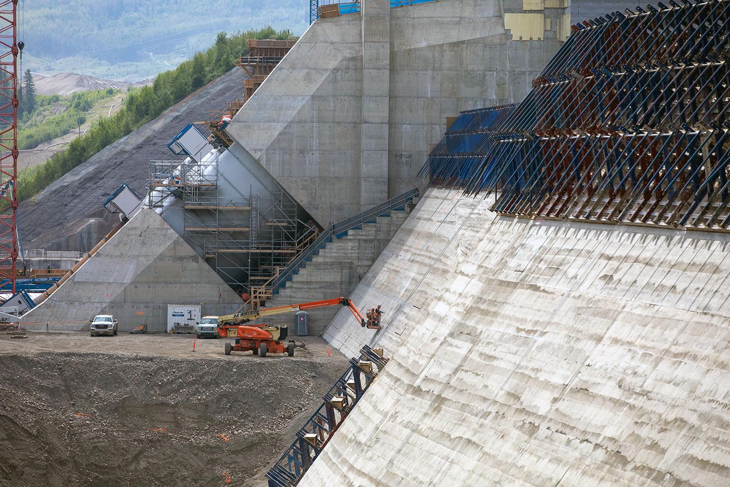 Workers inspect the roller-compacted concrete at the dam and core buttress after the formwork is removed. | June 2021