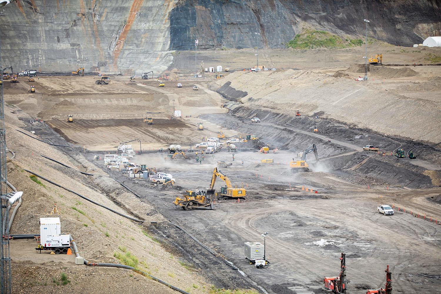 Crews prepare the left bank and remove of a top shale bedrock layer, to prepare for glacial till placement. | July 2021