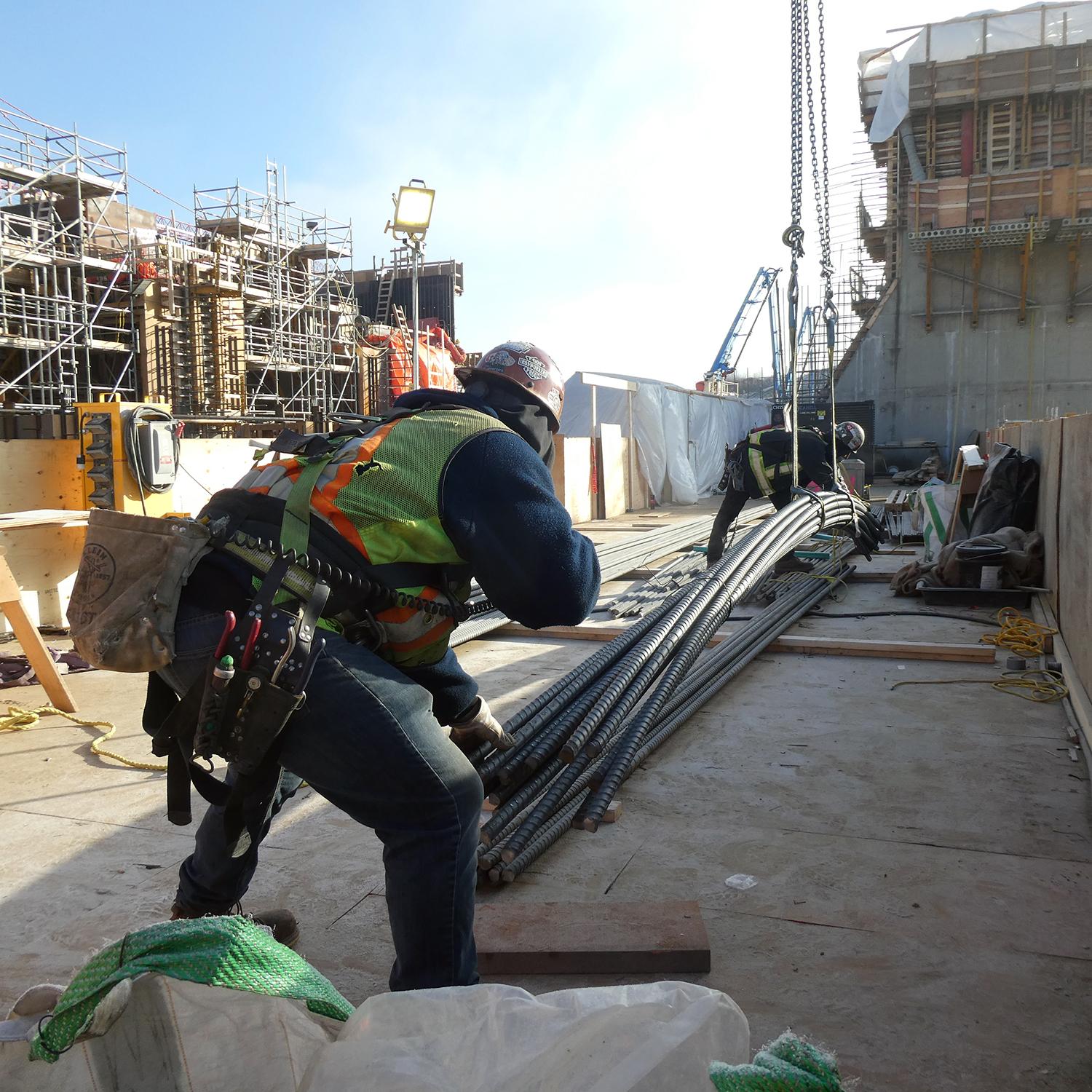 A lift of rebar is received and unhooked from the crane.