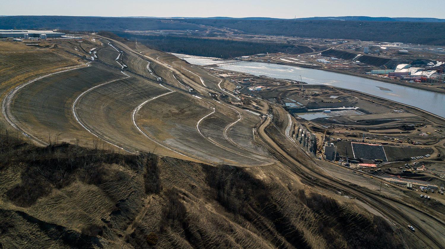 This slope has been flattened to remove excess material to ensure stability and will be the future left bank of the earthfill dam. | April 2020