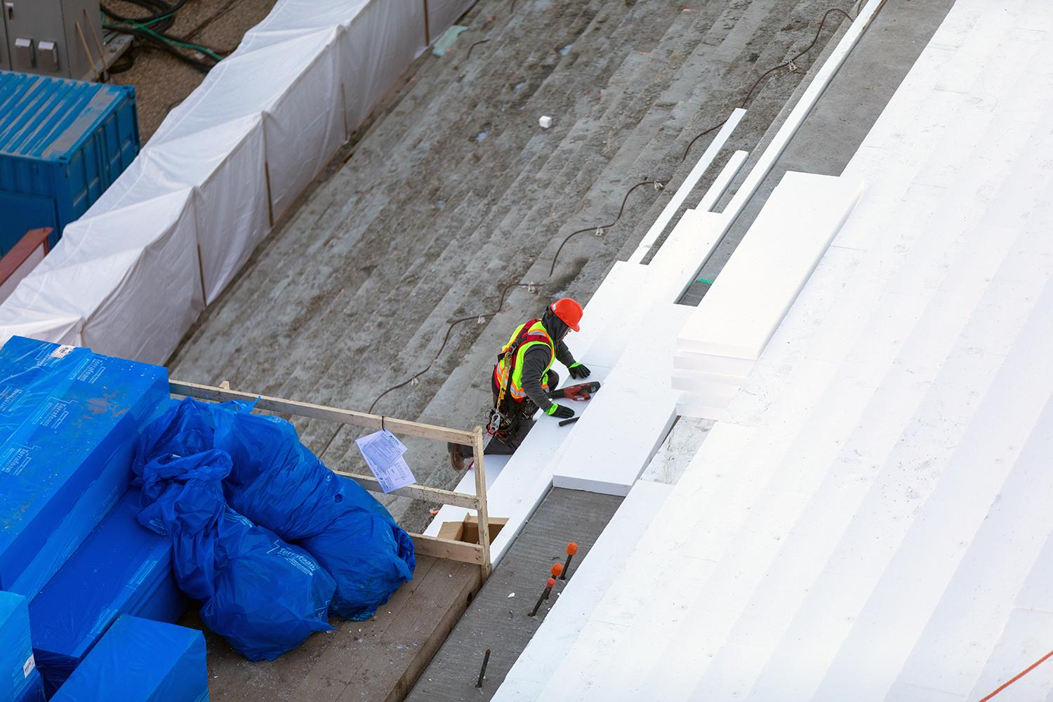 A worker insulates the steps and slope of the powerhouse buttress. As it gets colder outside it is necessary to reduce the temperature difference between the core and the surface of the concrete to prevent cracking. | October 2019