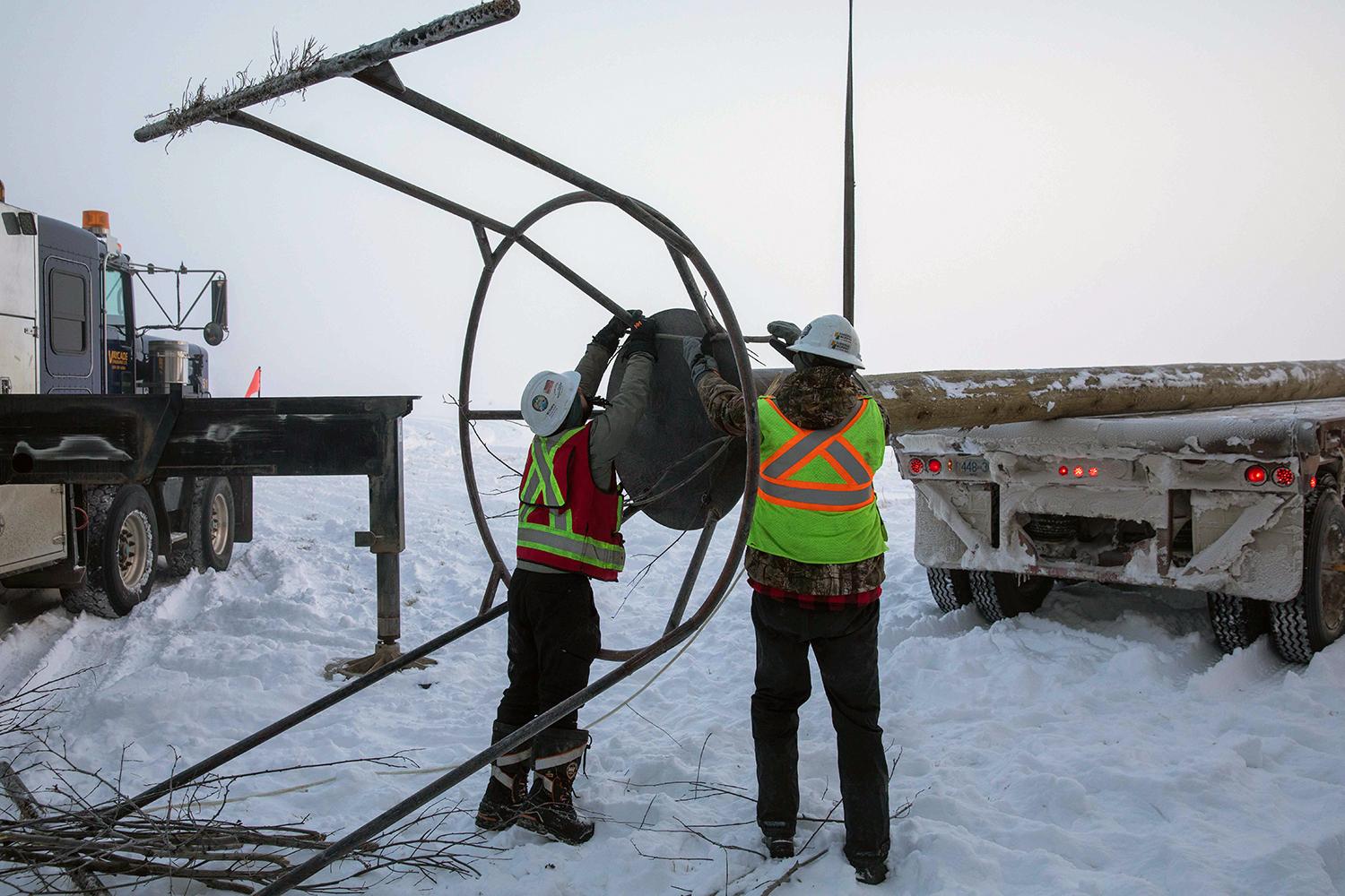 Workers attach a bald eagle nest structure to an 18-metre-long pole. | November 2020