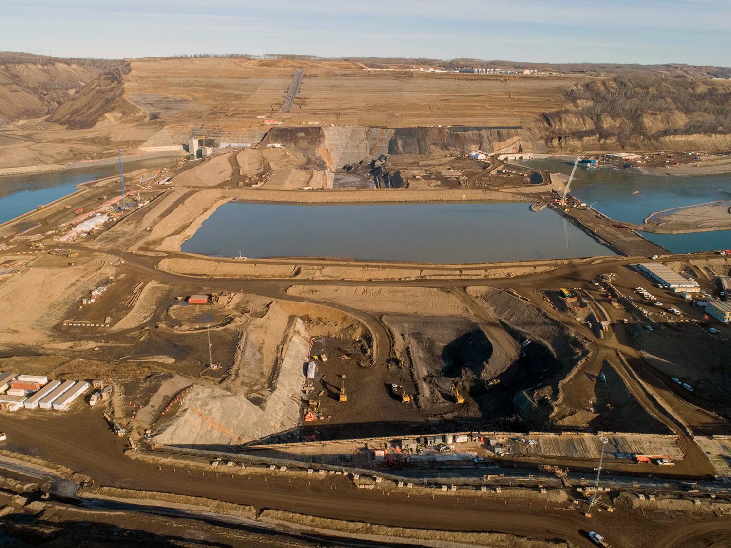 An aerial view of the south bank dam core trench looking north across the closed Peace River. | October 2020