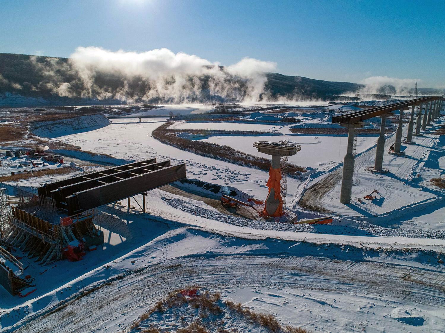 Halfway River bridge construction where the final girders will connect pier 12 to the eastern bridge abutment. In this area, the reservoir will cover the existing highway and bridge, requiring re-alignment of the highway and construction of a new bridge. This new segment of highway will be three kilometres long, and the new bridge will be one kilometre long. | January 2021