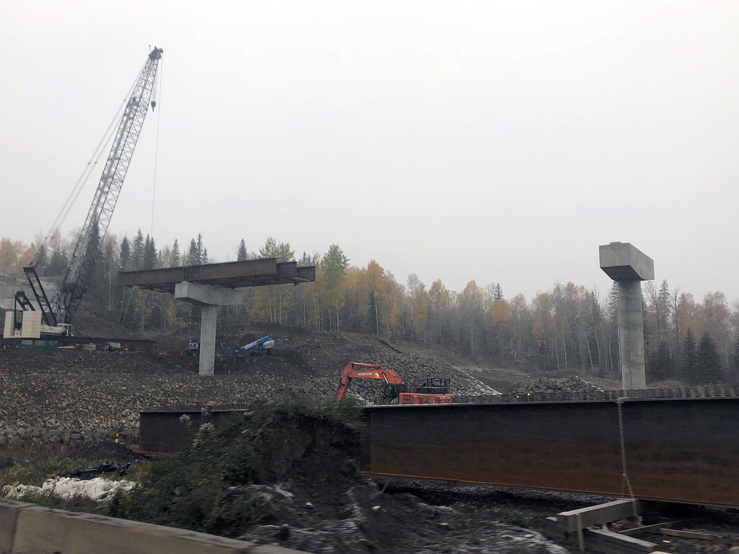 Bridge girders lifted onto Lynx Creek bridge piers; lateral steel members installed between girders. | October 2021