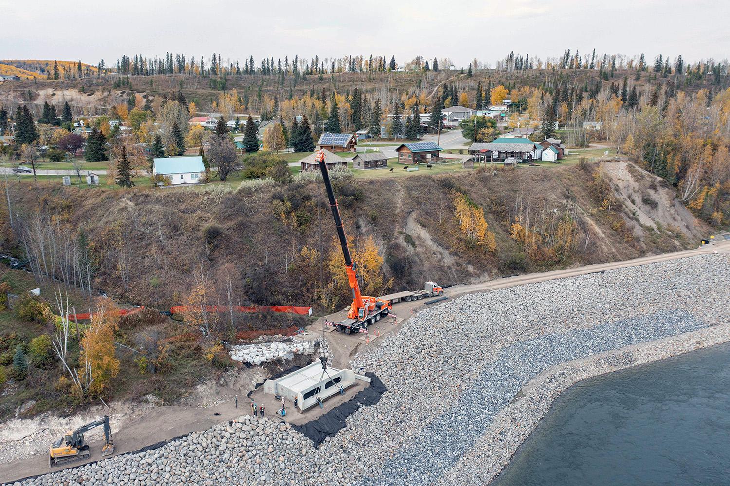 Crews install a concrete box culvert as part of construction of the Hudson’s Hope shoreline protection berm. | October 2022