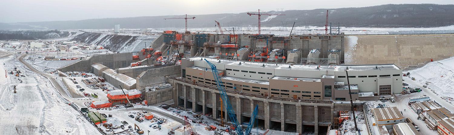 From left to right: Spillways, penstocks, powerhouse and operations building, with the tailrace galleries in front. | November 2022