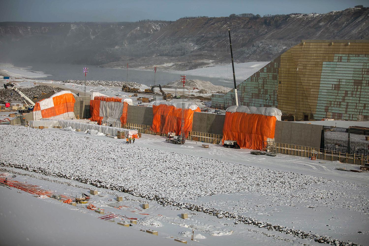 After concrete is poured, the approach channel wall is covered with winter hoardings to allow concrete to cure. | March 2023