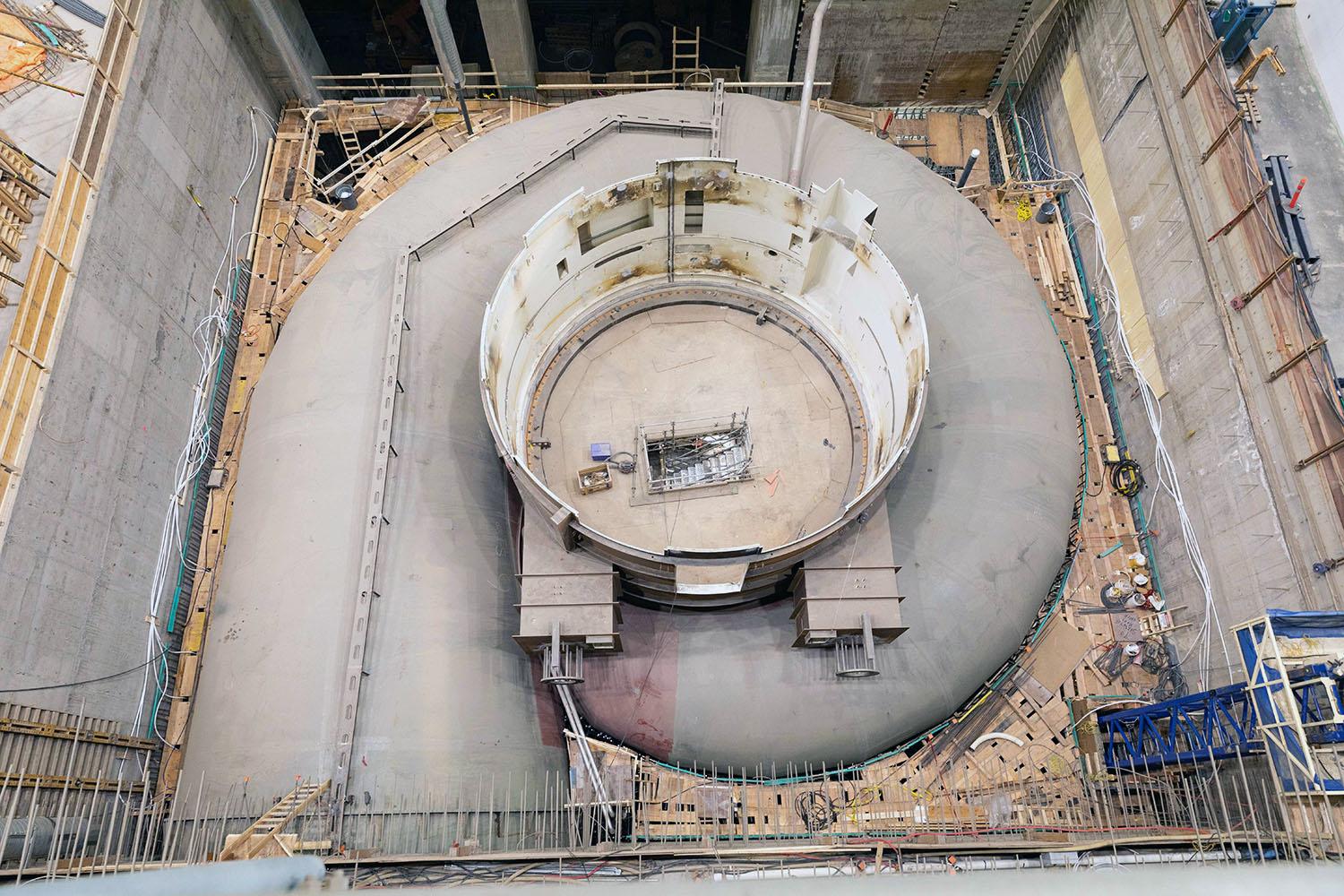 Turbine unit 6 is ready to be embedded in concrete.  A plywood deck has been placed on the reinforcing steel to allow the workers to place the concrete. | May 2023