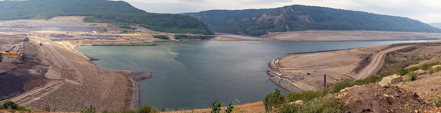 At left is the upstream side of the dam. The Peace River is flowing into the diversion inlet portal around the dam.