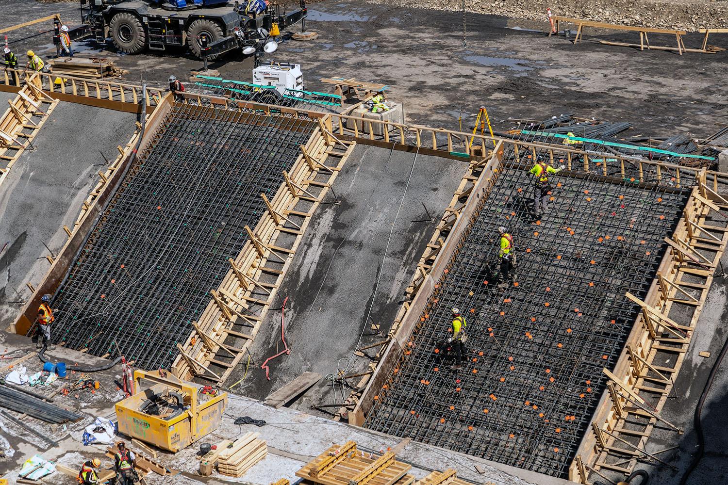 Workers install formwork and reinforcing steel on the tailrace bench.