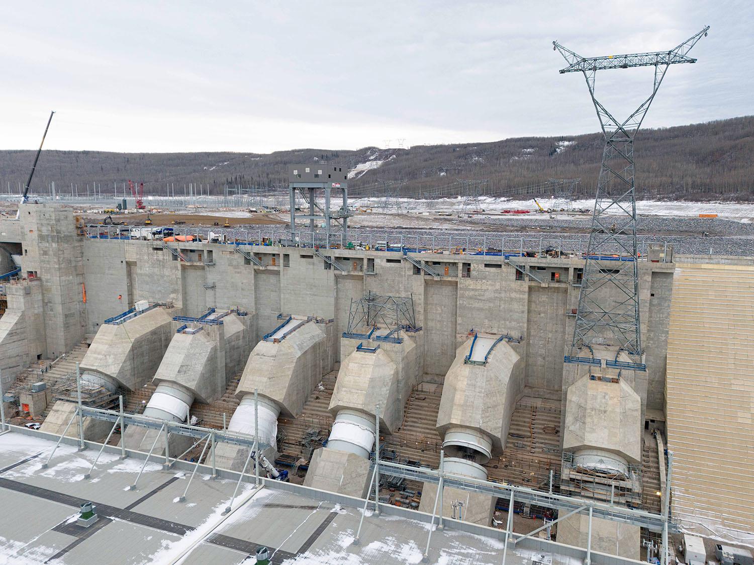 The first of three transmission towers sits on top of one of the penstock units. | November 2023