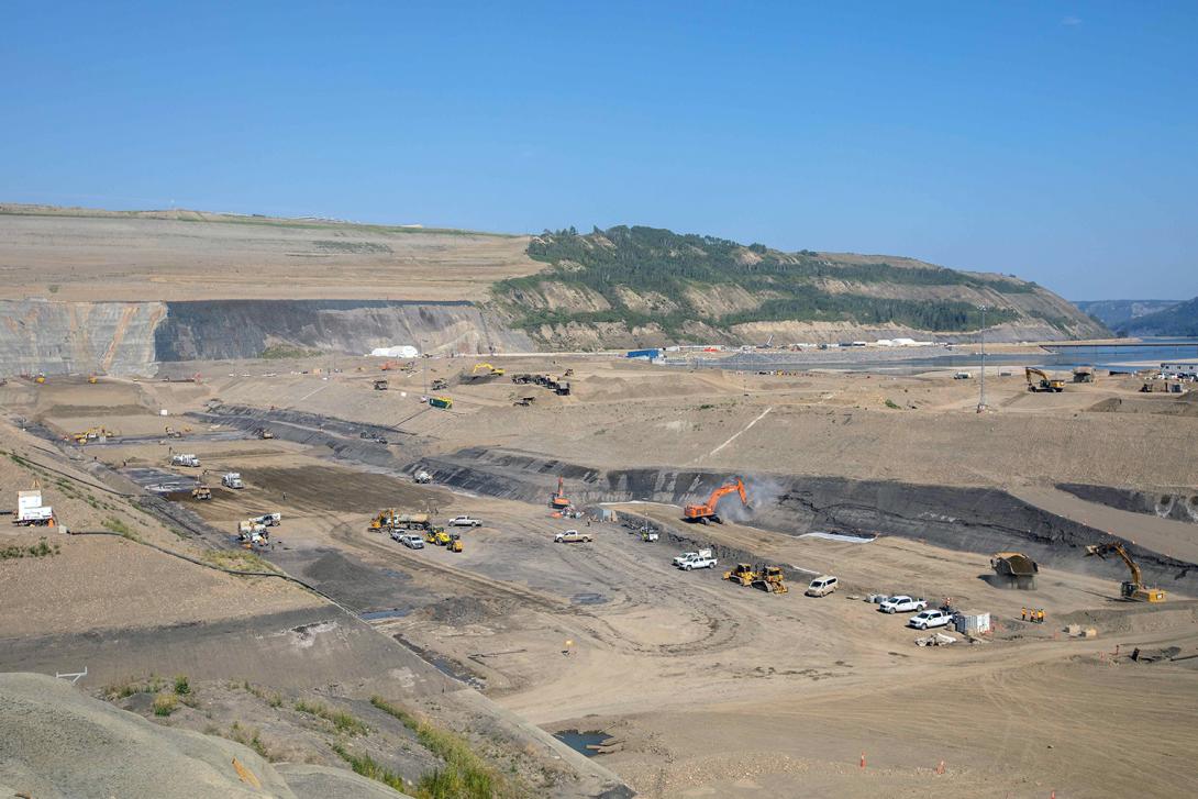 There is a lot of activity happening in the dam core trench, including drying glacial till, cleaning the bedrock layer and placing filters and aggregates. | August 2021