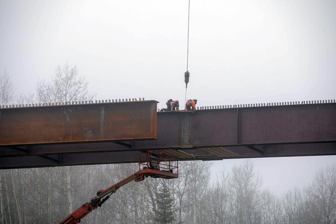 Workers install a girder splice plate to join two girders together on the Lynx Creek bridge along Highway 29  . | October 2021