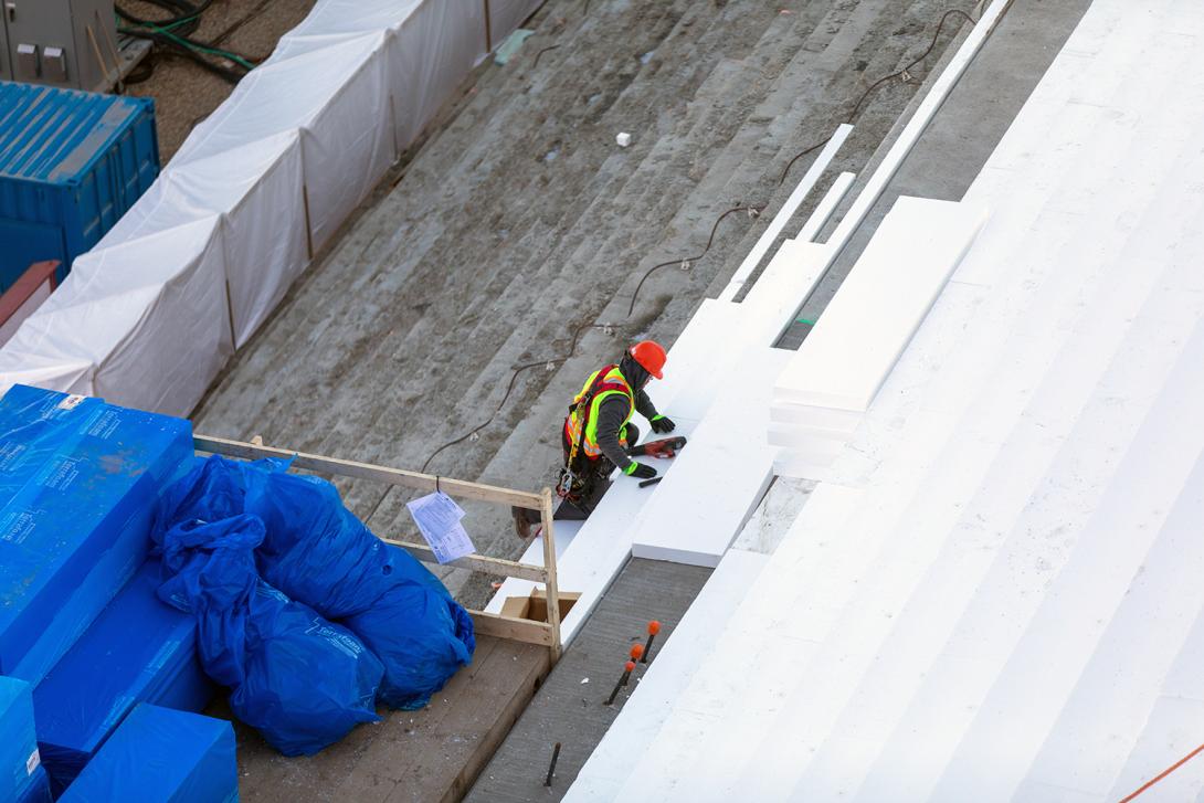 A worker insulates the steps and slope of the powerhouse buttress. As it gets colder outside it is necessary to reduce the temperature difference between the core and the surface of the concrete to prevent cracking. | October 2019 