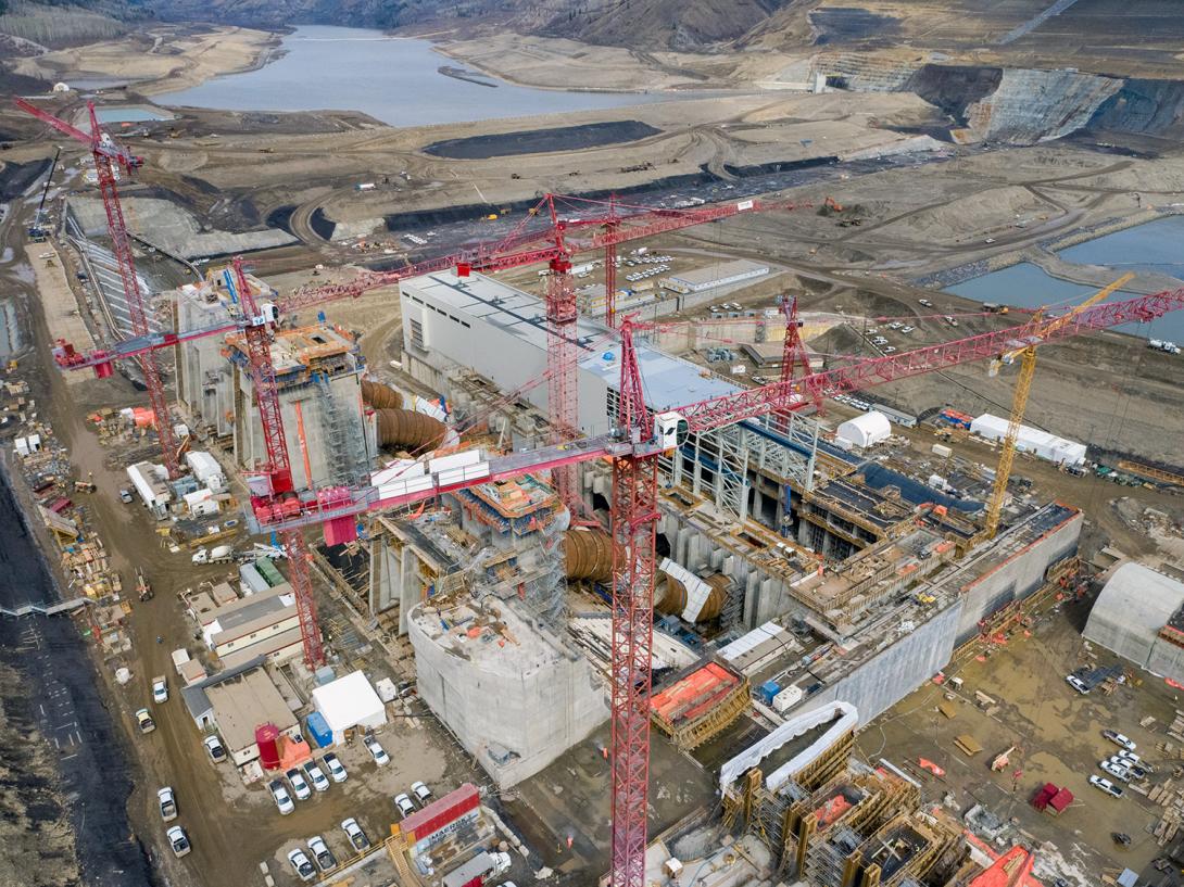 An aerial view of the generating station with the earthfill dam under construction in the background. | April 2021
