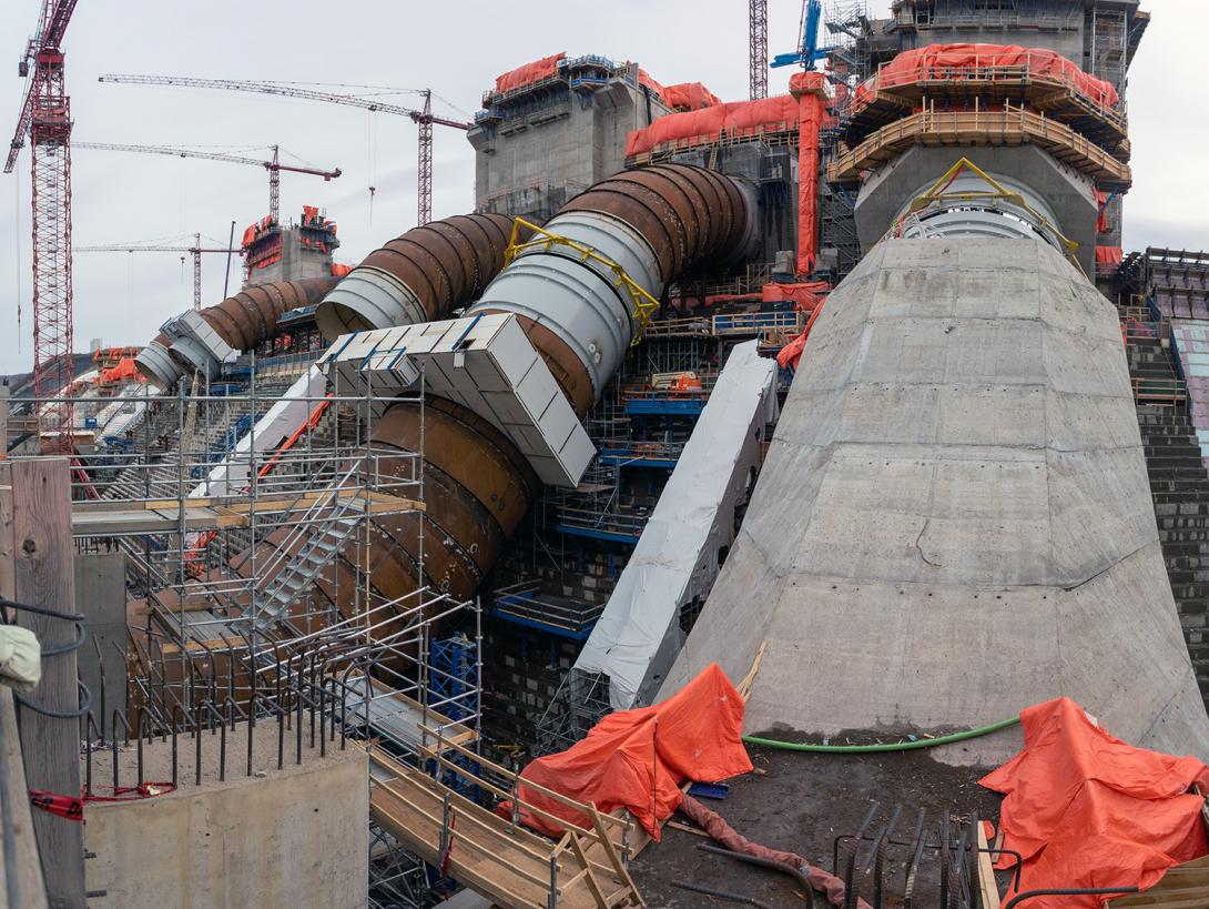 The generating station will have six penstocks to direct water into its six turbine and generator units. Unit 1 penstock is almost complete with crews currently working on the concrete casing. | April 2021 