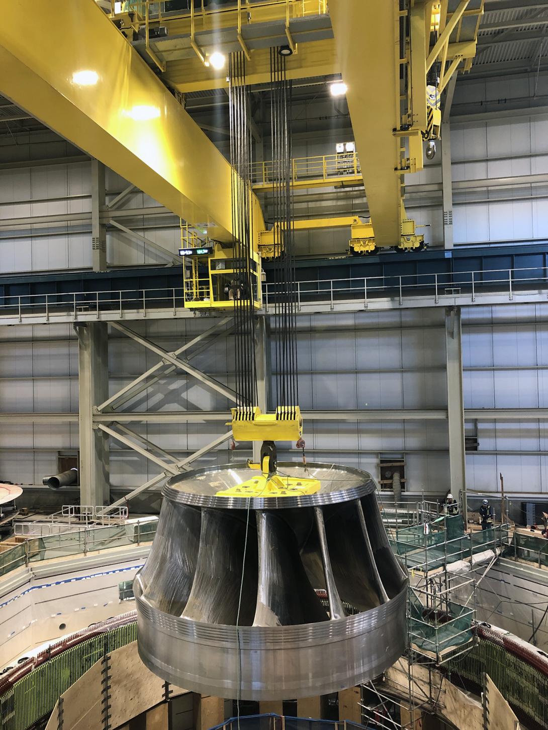 A 165-tonne turbine runner is lowered into the unit 1 turbine pit. | October 2022