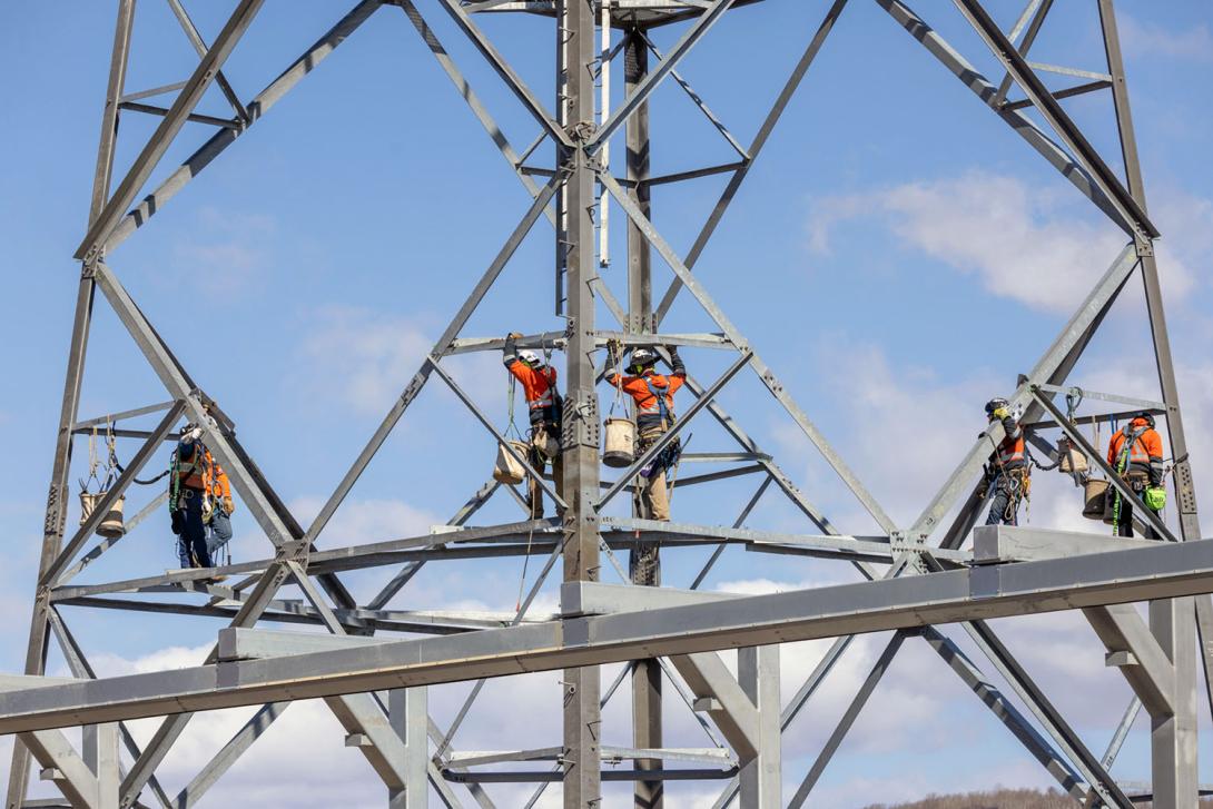 Connecting the second section of the transmission tower to the base. 