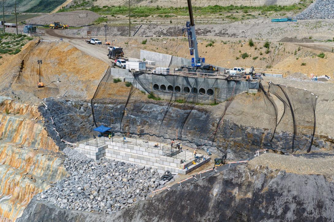 The left bank drainage structure includes a rip rap lined channel that flows through the box culvert. Fifteen layers of lock-blocks will complete the drainage structure to direct water into the reservoir away from the dam. | July 2024