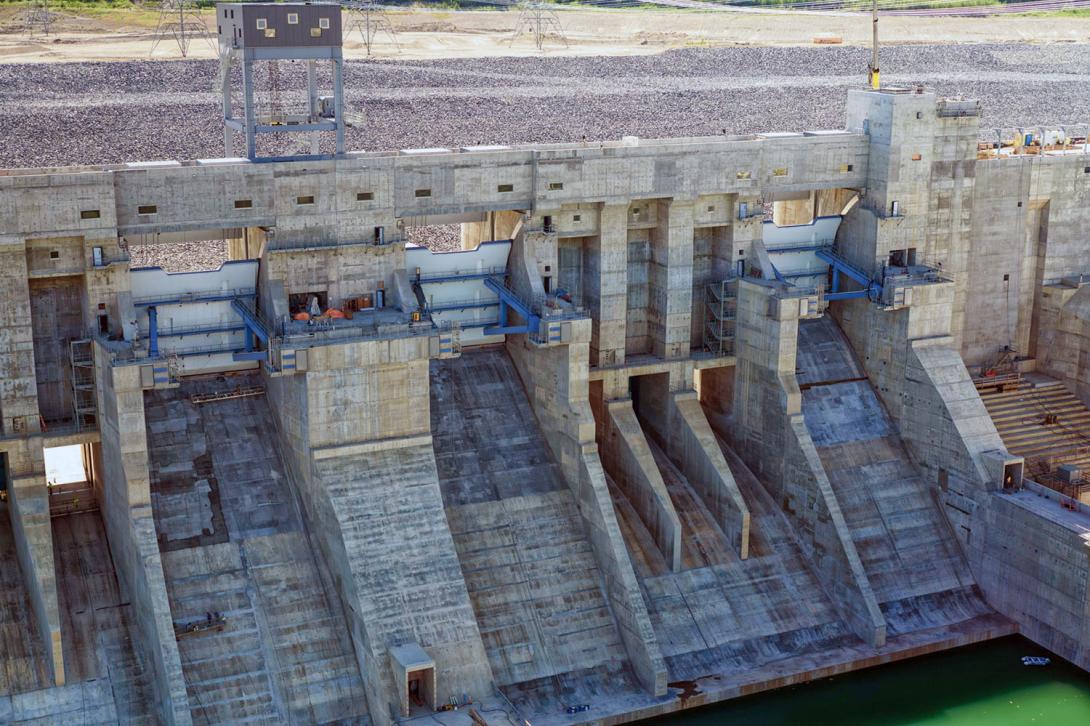 Workers are completing the dry finishing of the spillway concrete. | July 2024