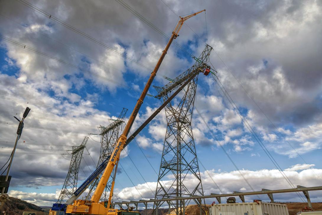 Powerline technicians prepare the third and final transmission tower for connection to the transformer. 