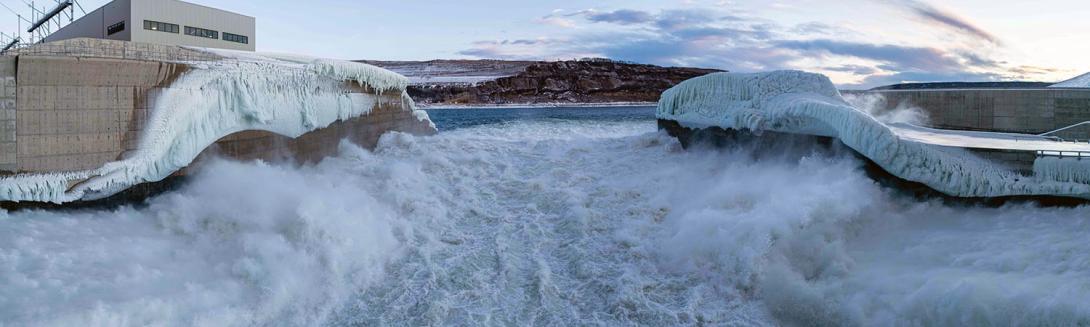 Water and spray freezes to the sidewalls of the stilling basin as it flows through the spillways downstream of the dam. | January 2025