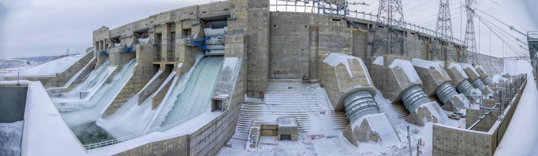 Panorama of the spillways and penstocks. Water is flowing to three units, and until four units are online water will continue to flow through the spillways. | February 2025