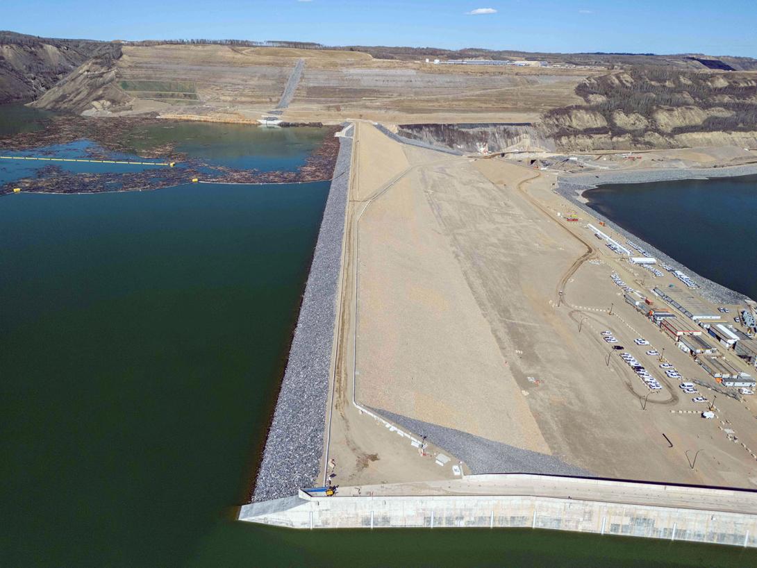 The Site C dam is 60 metres tall (about 20 storeys) and the earthfill section spans more than one kilometre to the concrete dam core buttress, bottom centre. | April 2025
