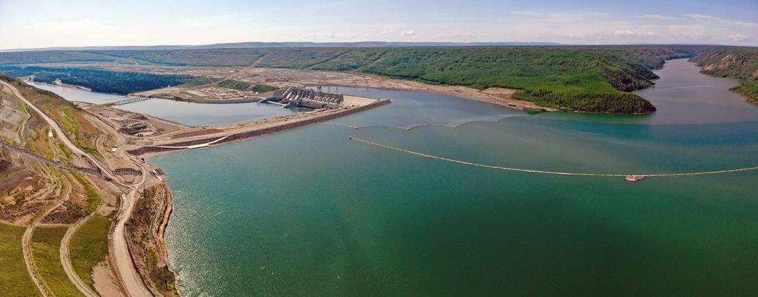 Upstream of the Site C dam and generating station, showing the debris boom collecting debris from the Moberly River, approximately one kilometre upstream of the approach channel. | June 2025